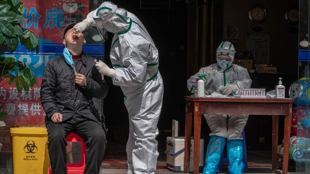 Un habitante de la ciudad de Wuhan, foco de inicio de la pandemia, recibe una prueba para detectar un posible contagio. ROMAN PILIPEY