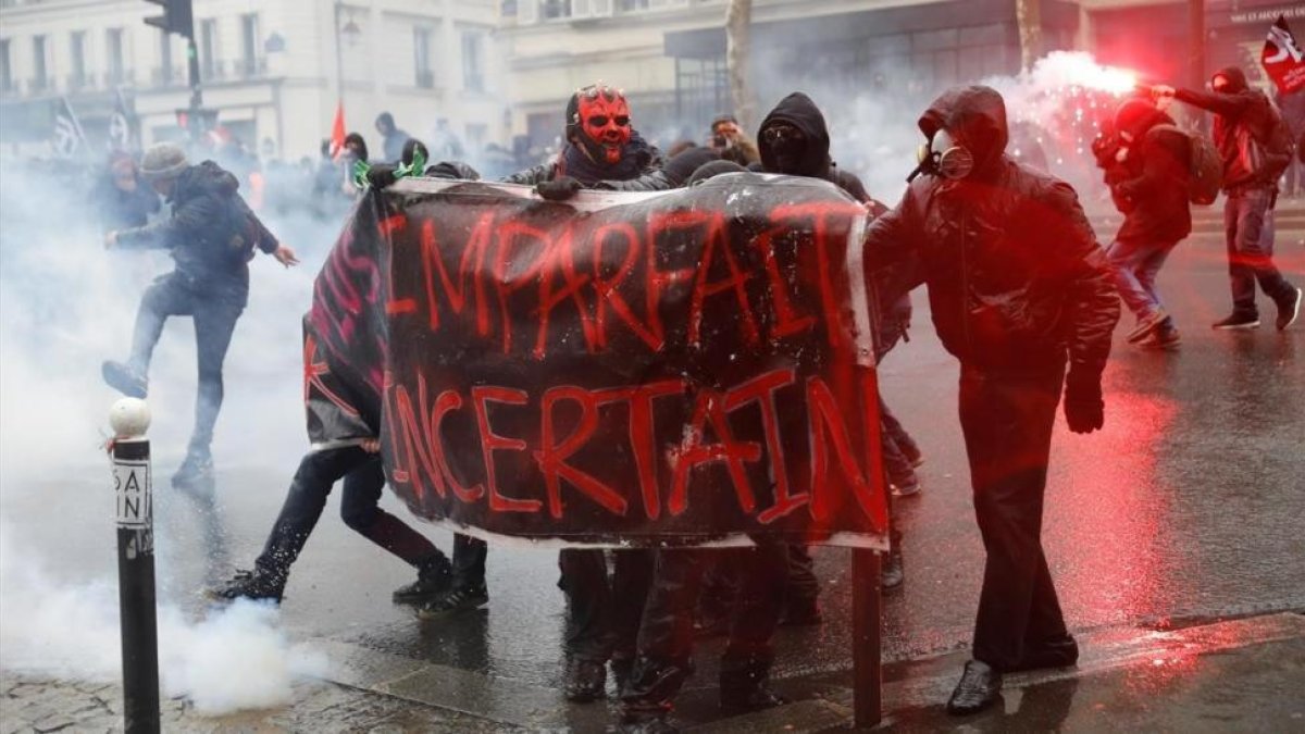 Manifestantes se enfrentan con la policia antidisturbios durante la huelga general en París.