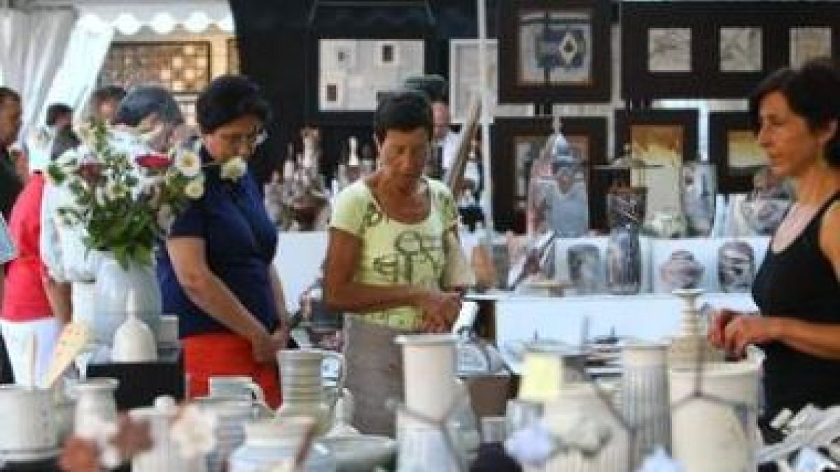 Artesanos ayer, en la feria pintando con fuego.