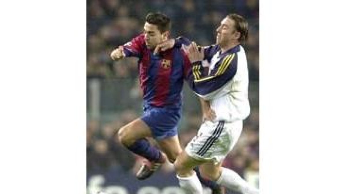 El barcelonista Xavi se zafa de su marcador Jean Simeak