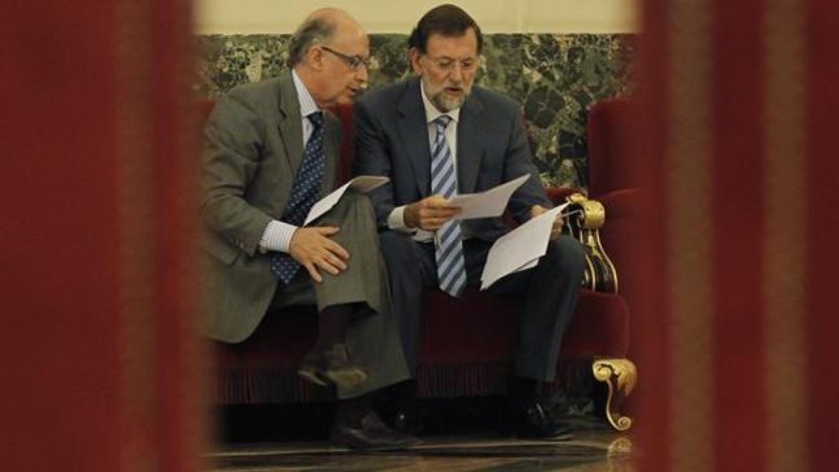 Montoro y Rajoy estudian unos papeles durante un pleno en el Congreso.