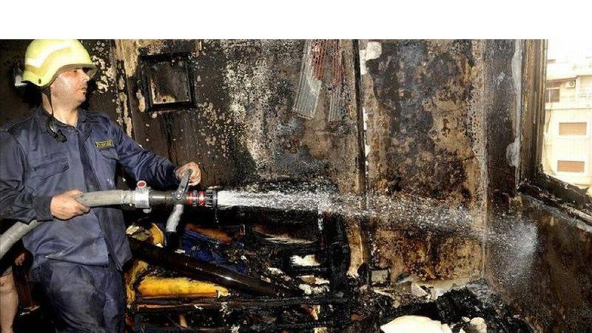 Un bombero intenta apagar un incendio causado por un mortero en una casa de Damasco, este martes.
