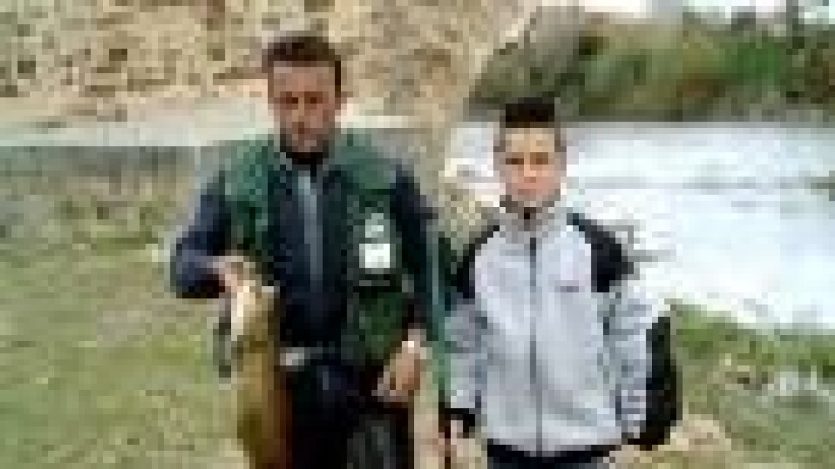 José Manuel Nistal y su hijo Adrián, con una trucha de 2.500 gramos recién pescada