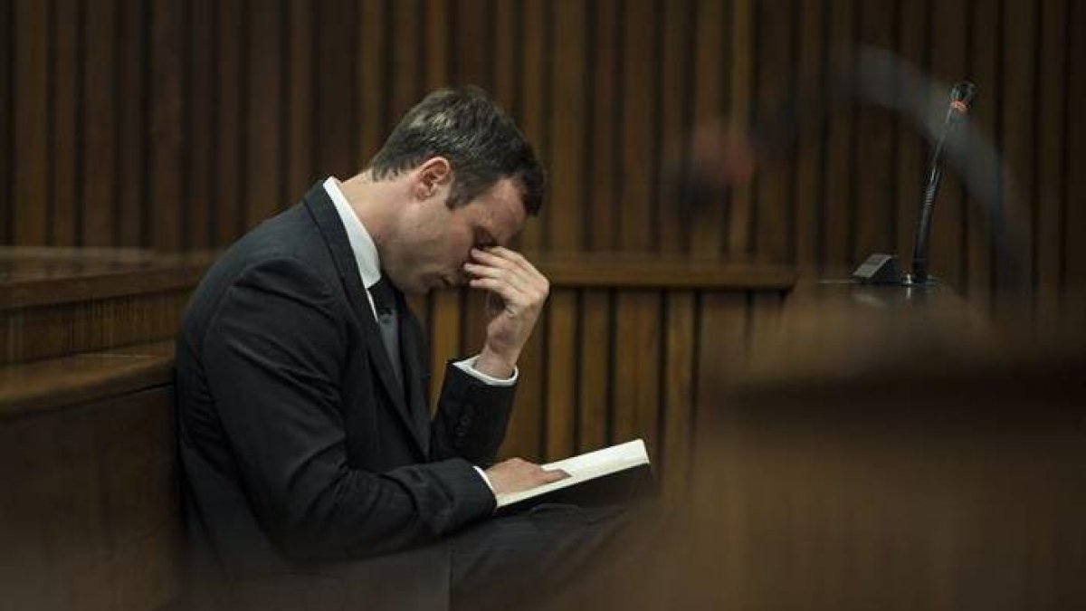 El atleta paralímpico Oscar Pistorius permanece sentado en el banquillo de los acusados durante una nueva sesión de su juicio por el asesinato de su novia Reeva Steenkamp.