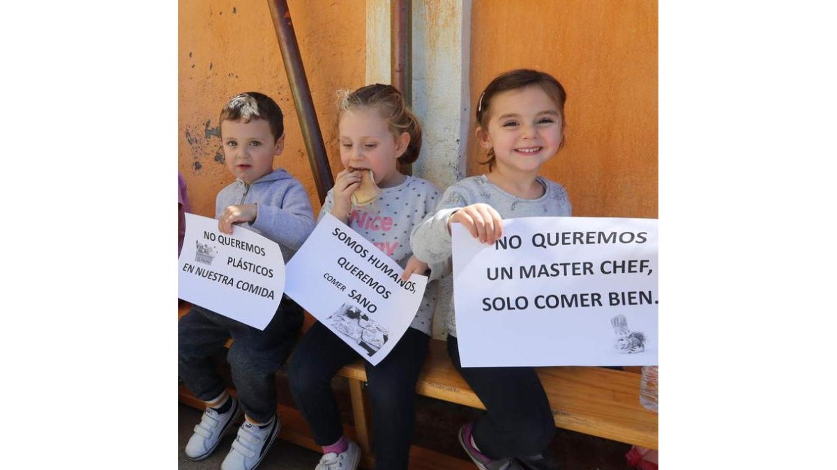 Tres niñas sostienen mensajes de protesta por la comida. L. DE LA MATA