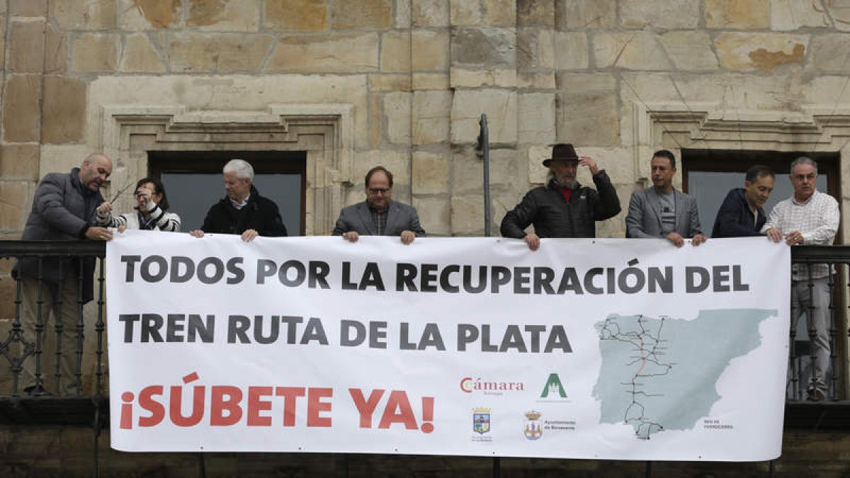 Autoridades de Astorga y La Bañeza, organizaciones empresariales y asociaciones ferroviarias, en el despliegue de la pancarta. FERNANDO OTERO