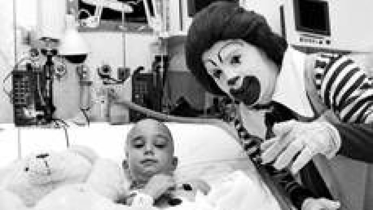 Un payaso visita en el hospital a un niño enfermo
