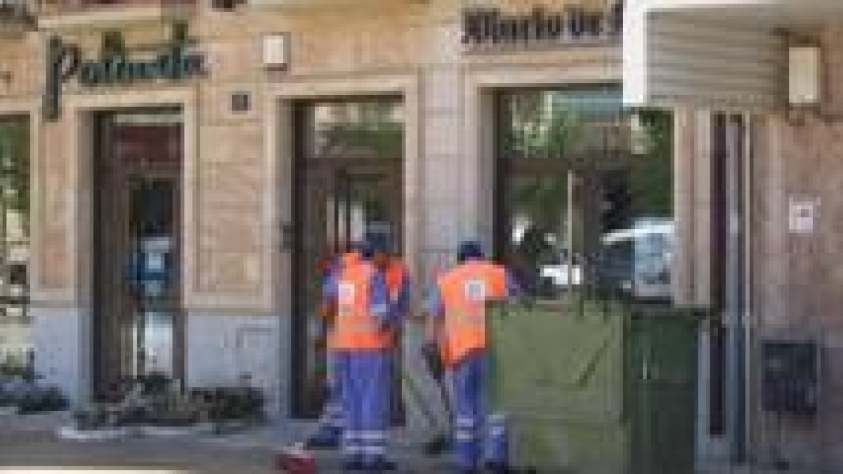 Unos operarios del servicio de limpieza adecentan uno de los laterales de la plaza de Santocildes