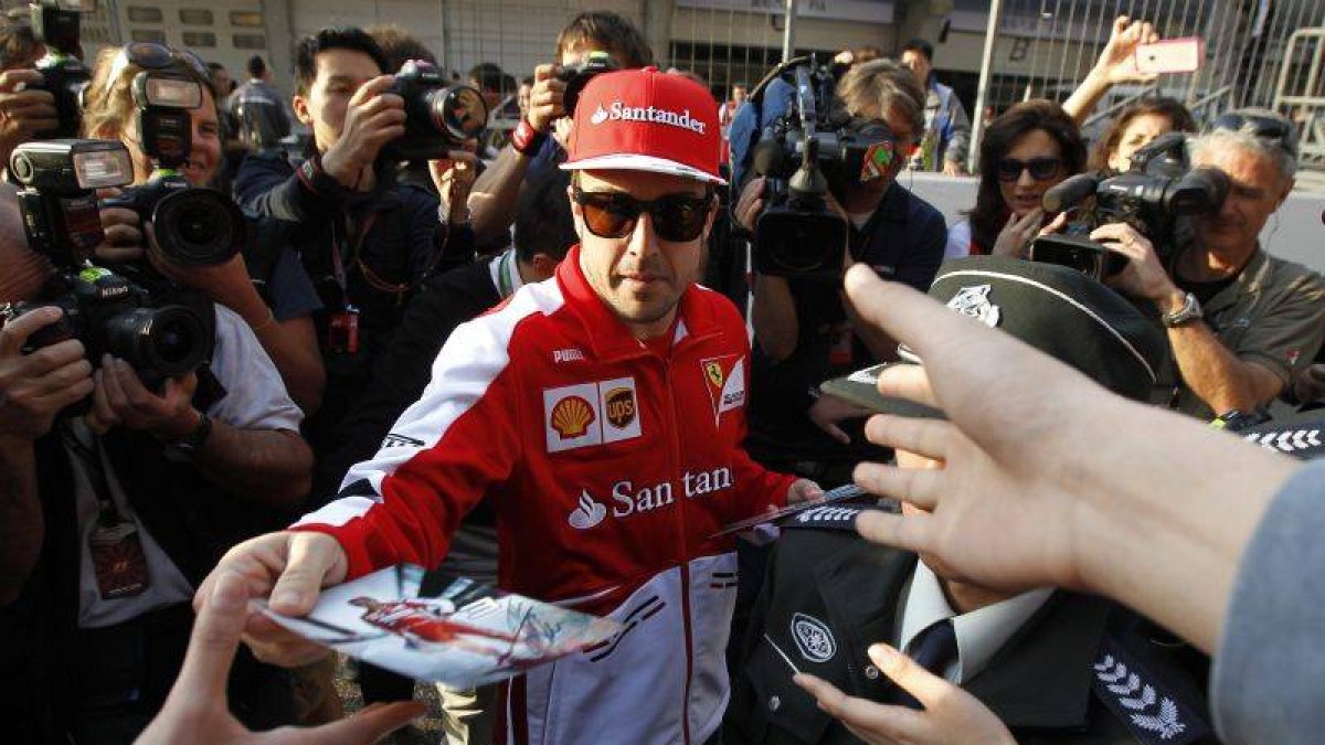 Fernando Alonso firma autógrafos a sus seguidores en Shanghái.