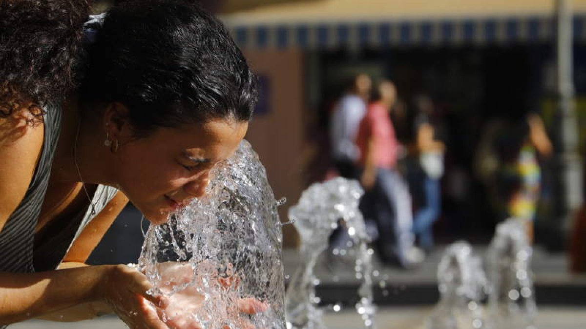 Une mujer se refresca en Córdoba en plena ola de calor en agosto de este año. SALAS