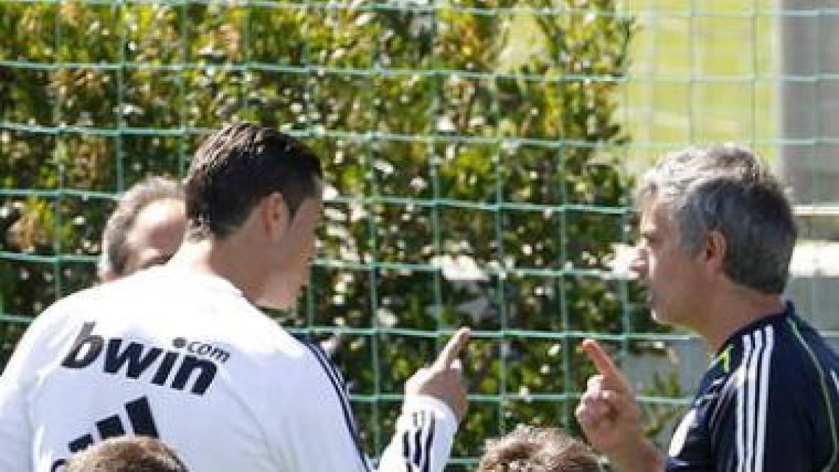 Cristiano Ronaldo (2º i) conversa con José Mourinho (2º d), durante el entrenamiento del Real Madrid