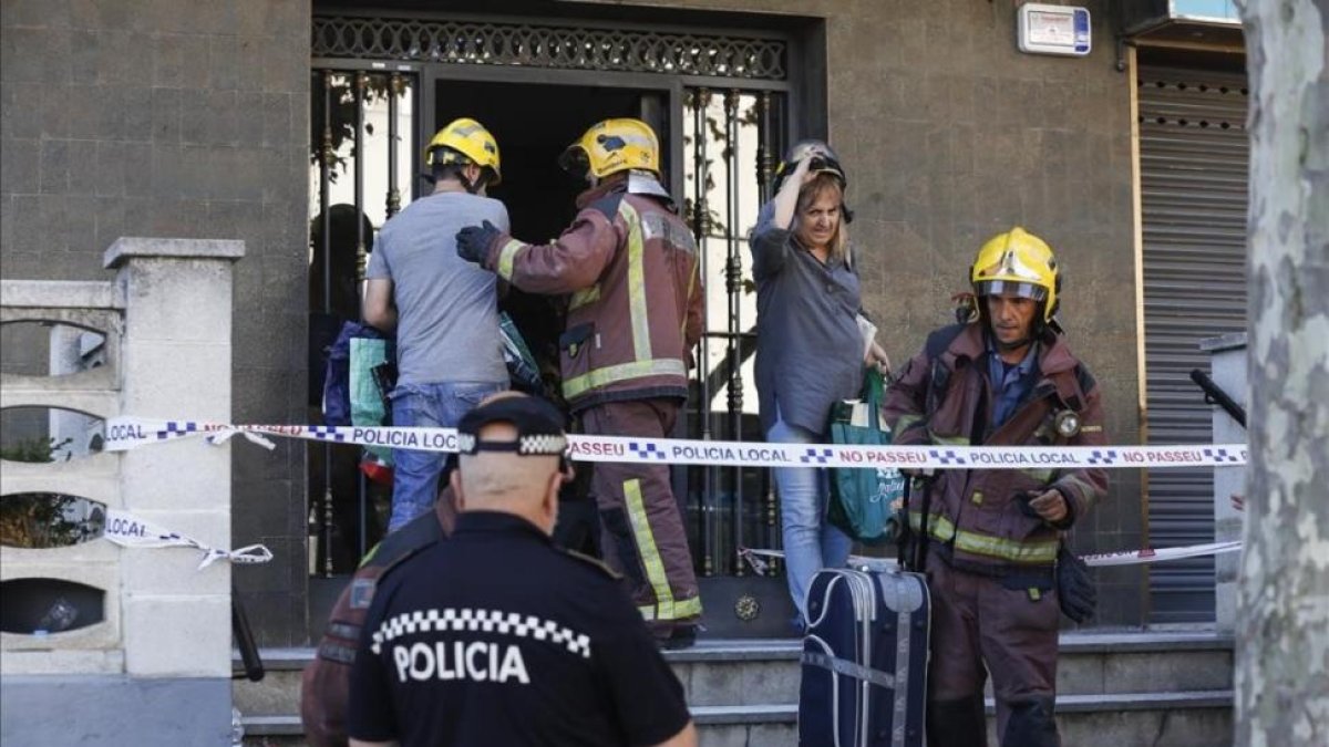 Uno de los vecinos sube acompañado por un bombero a su vivienda para recoger algunas pertenencias personales.