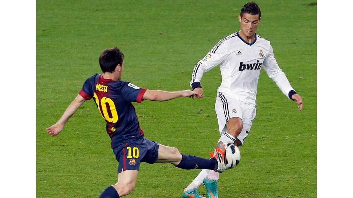 Messi y Cristiano Ronaldo luchan por el balón durante un Madrid-Barcelona.