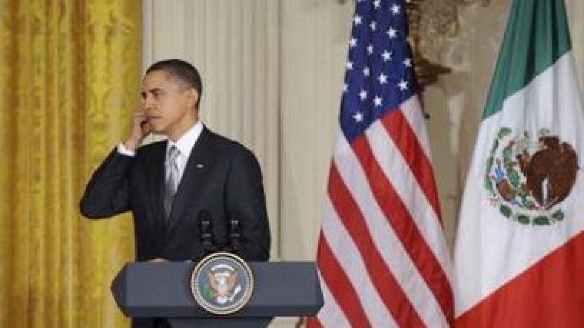 Obama se ajusta un auricular en la rueda de prensa con su homólogo mexicano, Calderón.