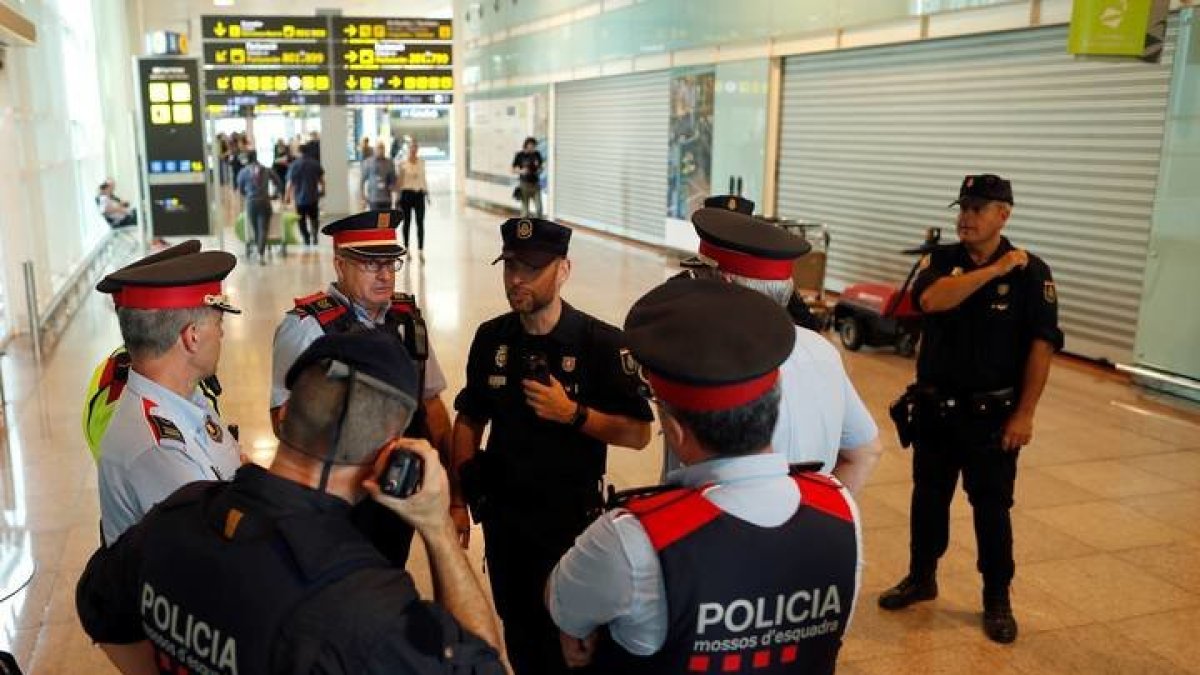 Mandos policiales de los Mossos y del Cuerpo Nacional de Policía en el aeropuerto del Prat. ALEJANDRO GARCÍA