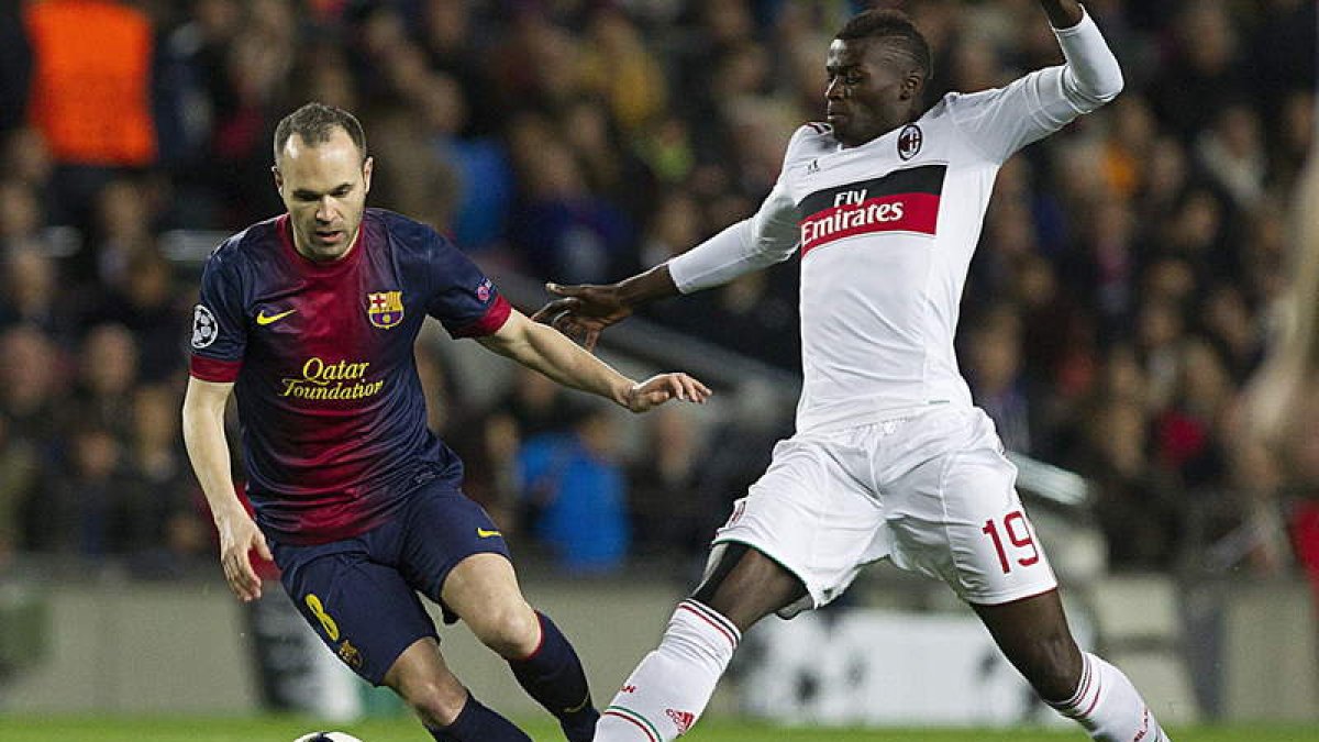 El centrocampista del Barça, Andrés Iniesta, pelea un balón con el delantero del Milan, M’Baye Niang, durante el partido de ayer en el Nou Camp.