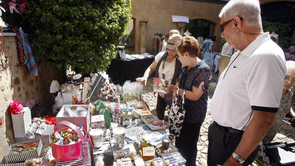 Los visitantes se interesan por algunos de los productos que se pueden adquirir en el mercado.