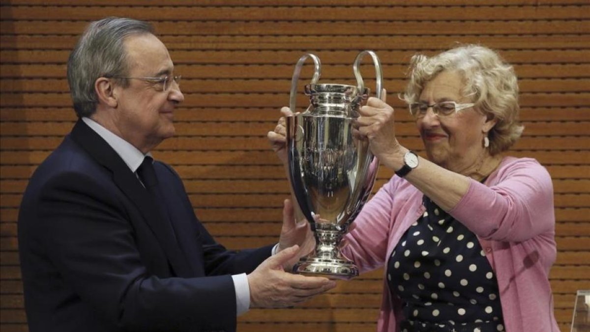 Florentino Pérez le entrega a Manuel Carmena, alcaldesa de Madrid, una réplica de la Champions.