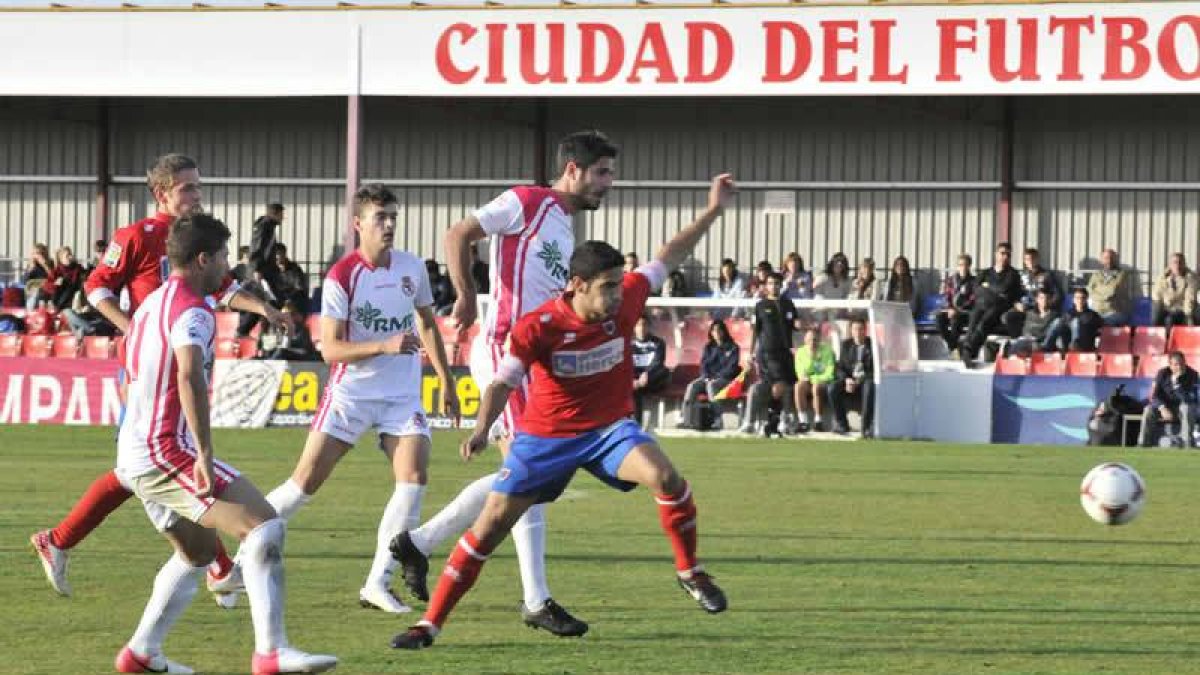 Hedrera trata de controlar el balón ante la presión del jugador local Plaza en un lance del partido disputado en Soria.