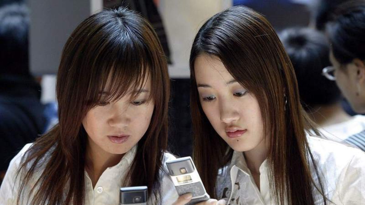 Dos mujeres se muestran mensajes a través de sus ‘smartphones’. MICHAEL REYNOLDS