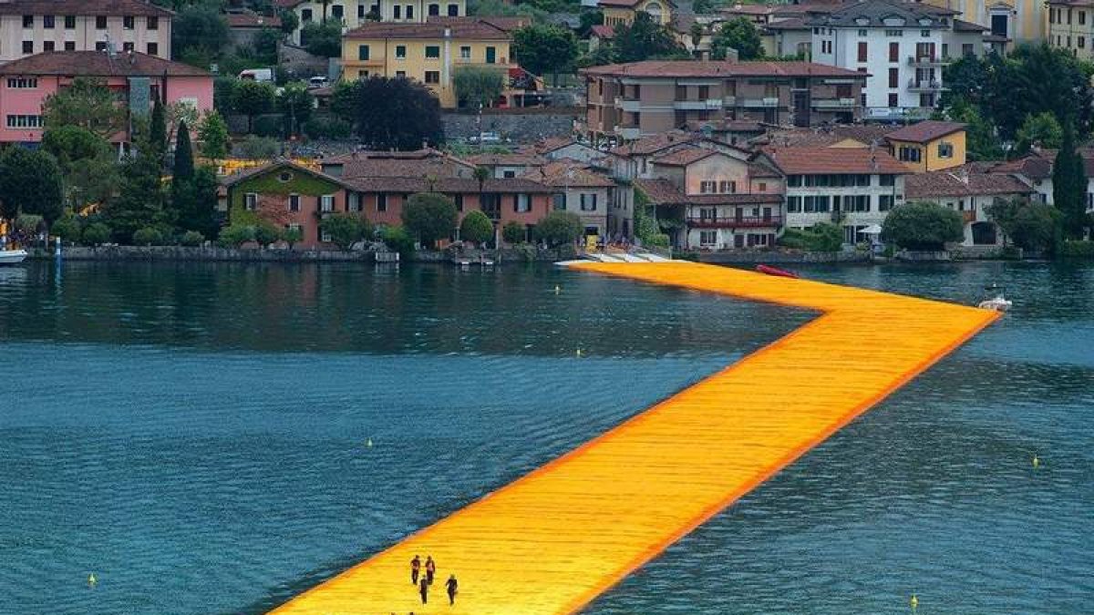 Algunos visitantes caminan por la pasarela montada sobre el agua en el lago italiano Iseo. MICHELANGELOOP / SHUTTERSTOCK.COM