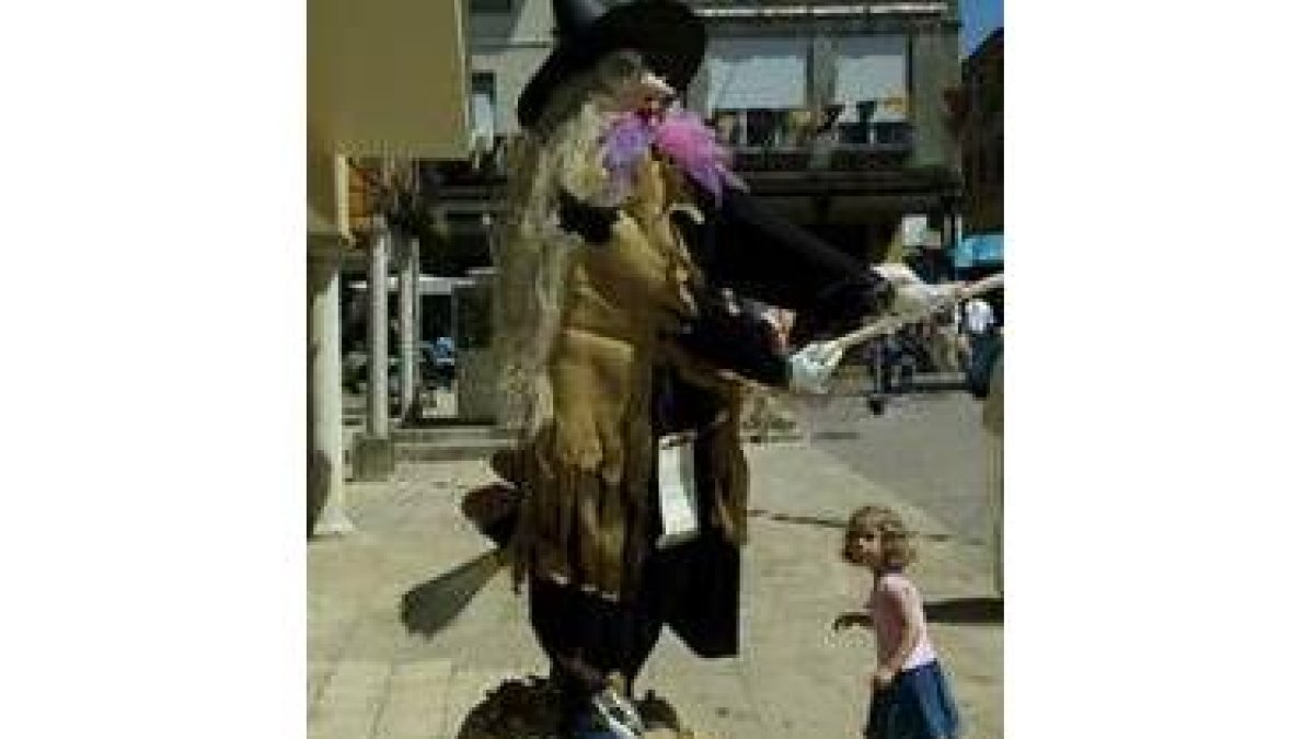 Una niña observa asombrada una bruja en las calles de Sahagún