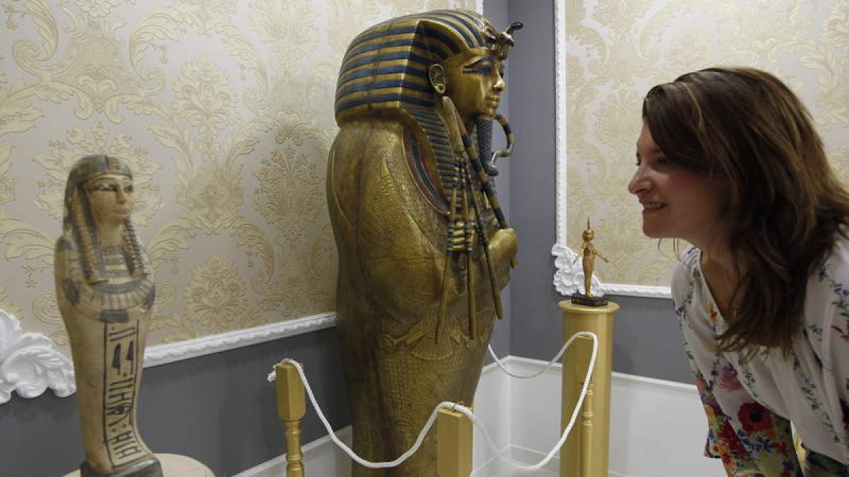 Una mujer contempla una pieza del Museo-Liceo Egipcio; a la derecha, la réplica del sarcófago de Tutankamon.