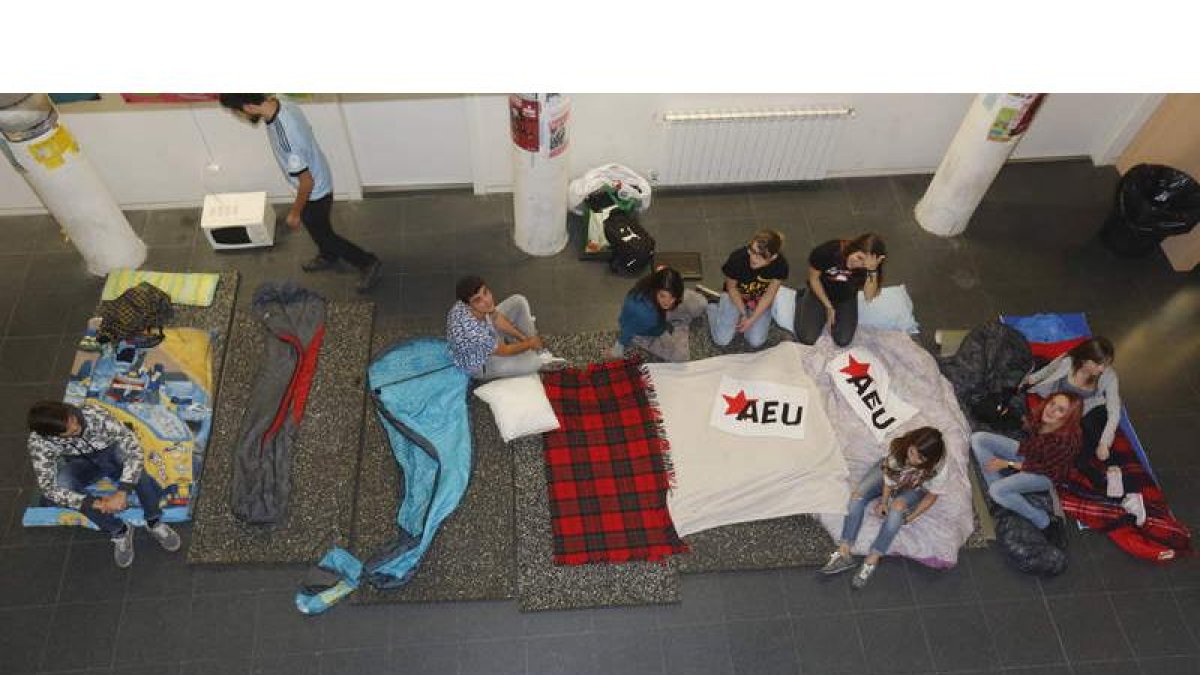 Los primeros jóvenes que llegaron a Educación preparan sus sacos de dormir para pasar la noche en el recibidor