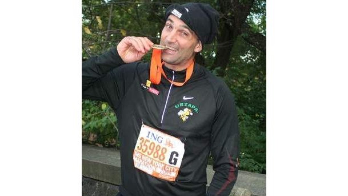 El atleta leonés Urbano Gonzálezmuerde la medalla que le entregó la organización.