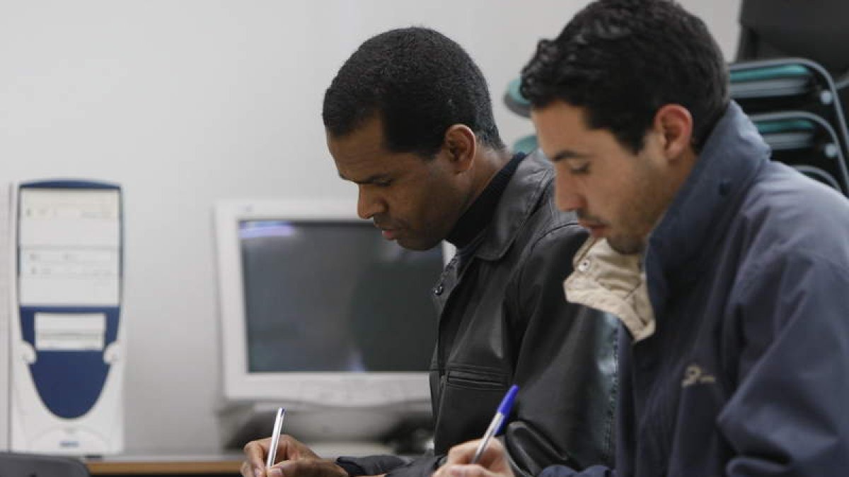 Dos inmigrantes asisten a clases de español.
