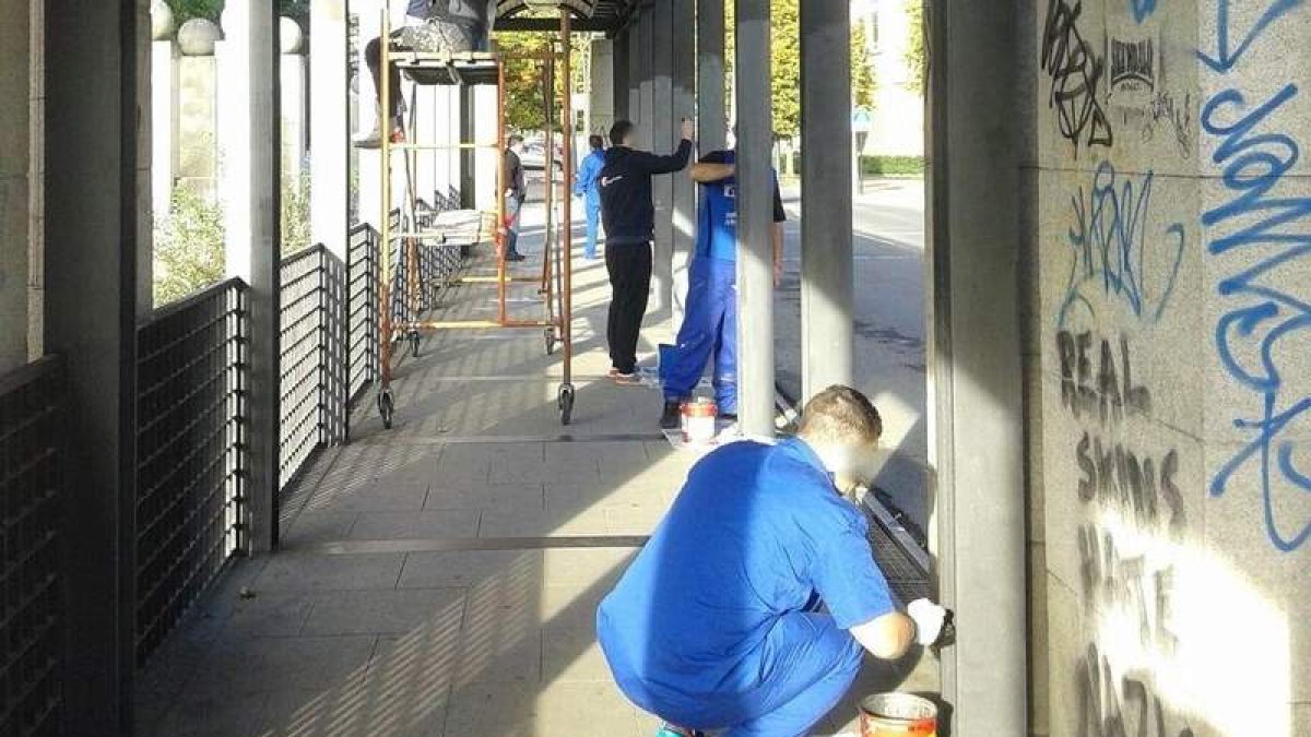 Usuarios de Proyecto Hombre trabajan sobre los grafitis del puente de los Faraones, en una imagen de archivo.
