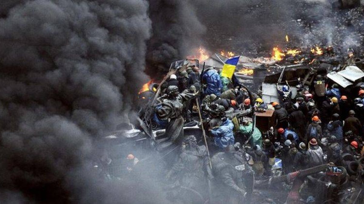 Manifestantes detrás de las barricadas durante los enfrentamientos contra la policía en Kiev.