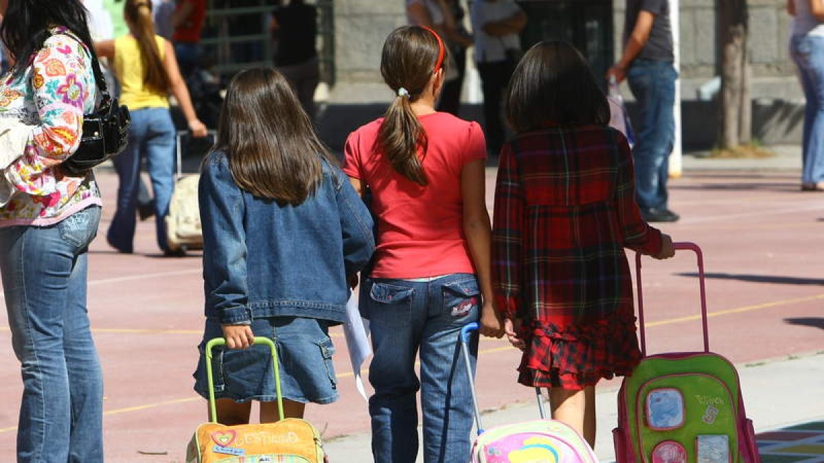 Tres niñas, como cada mañana, a la entrada de uno de los colegios del Bierzo.