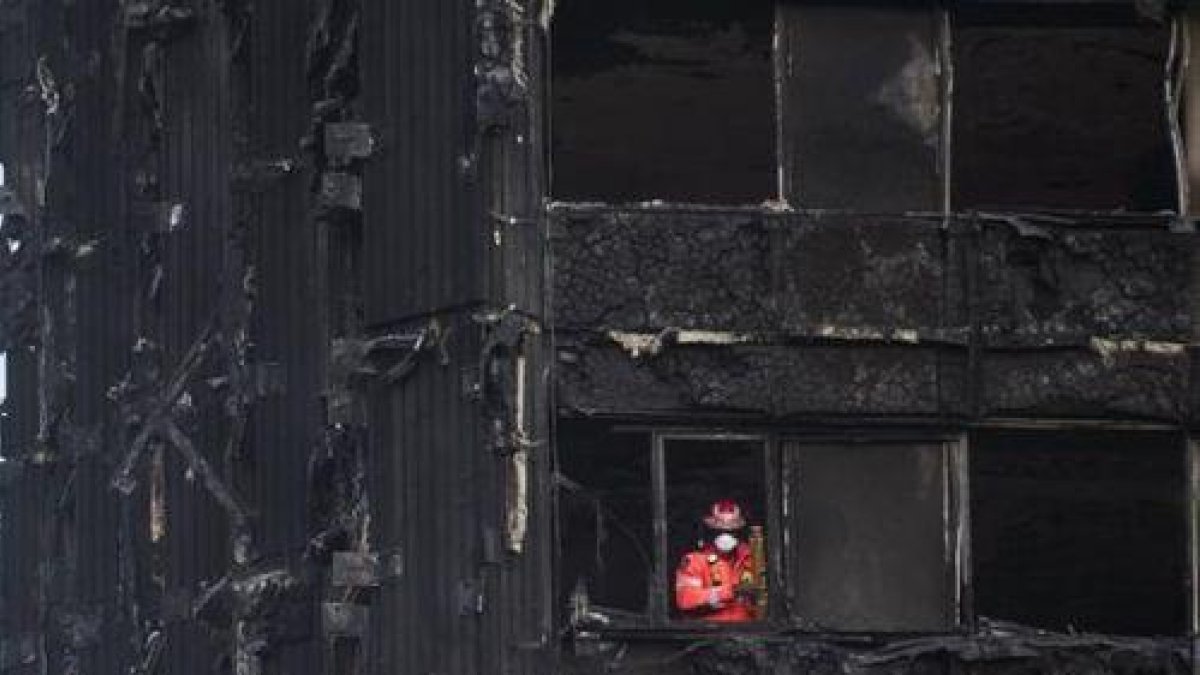Un bombero inspecciona los restos de la Torre Grenfell, el edificio de apartamentos de 24 plantas en North Kensington, que se incendió el pasado sábado.