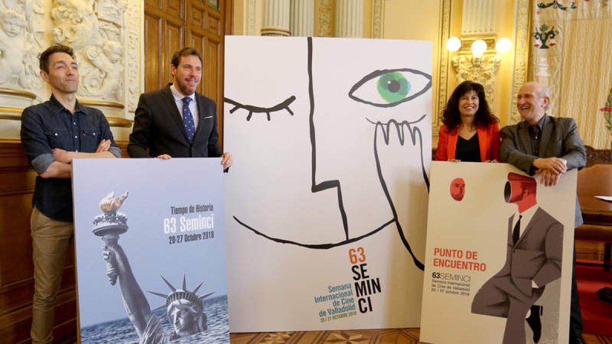 Jorge Barrientos, a la izquierda, y su cartel ganador en el centro de la foto. LETICIA PÉREZ