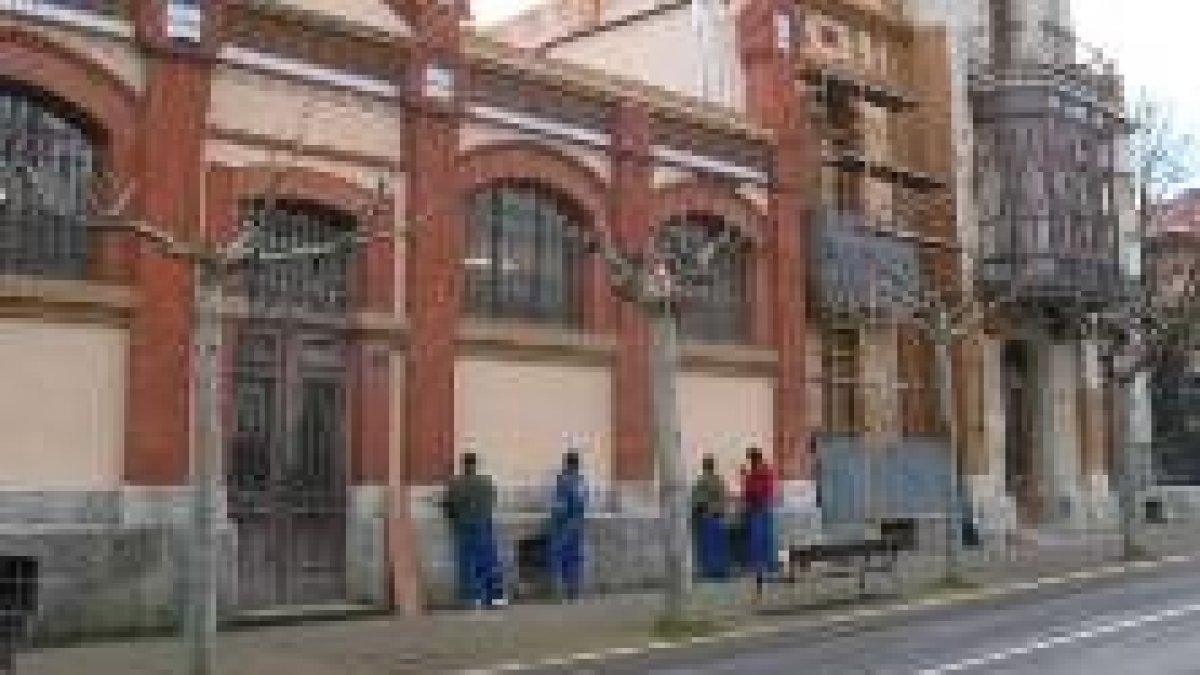 Varios alumnos pintan la fachada principal de la escuela