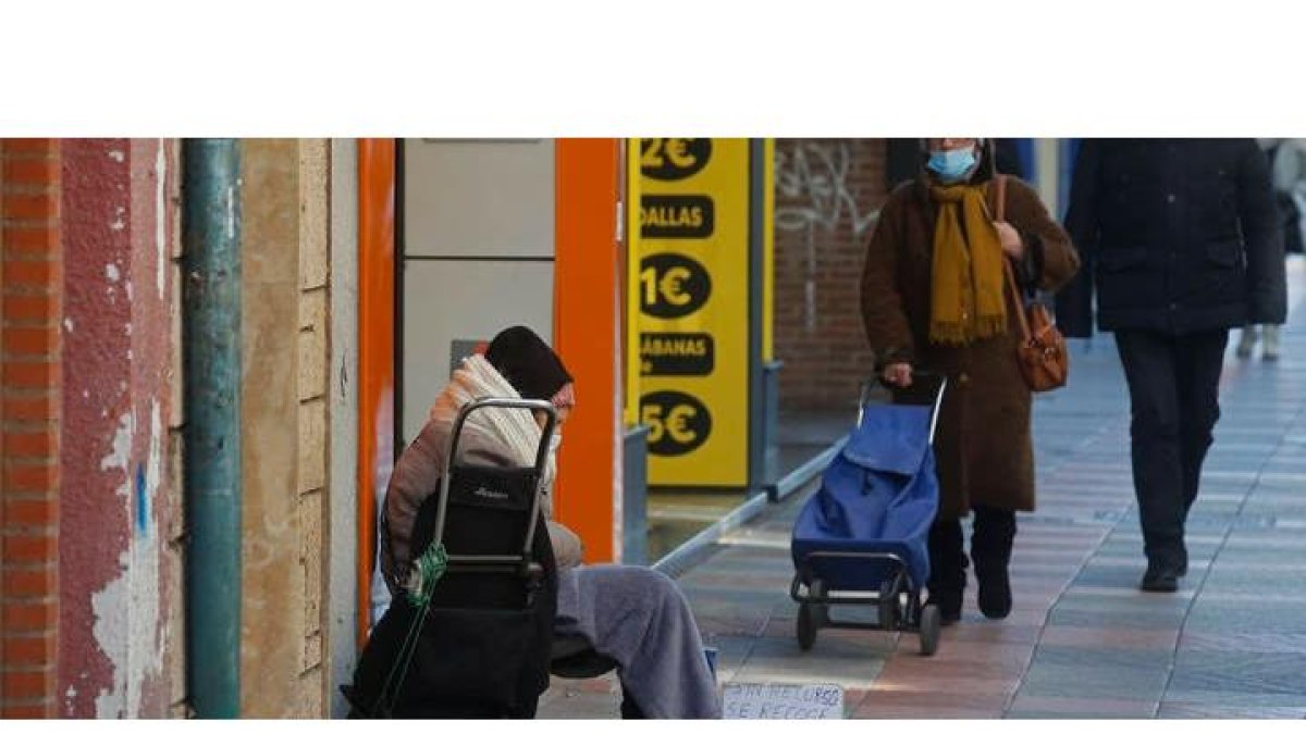 Una mujer pide en una céntrica calle de León. FERNANDO OTERO