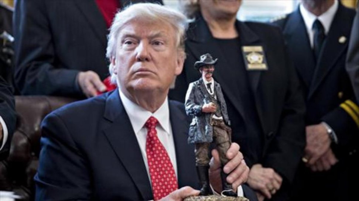 Trump sostiene una figura con la que fue obsequiado en la reunión que mantuvo ayer con los 'sheriffs' del país.
