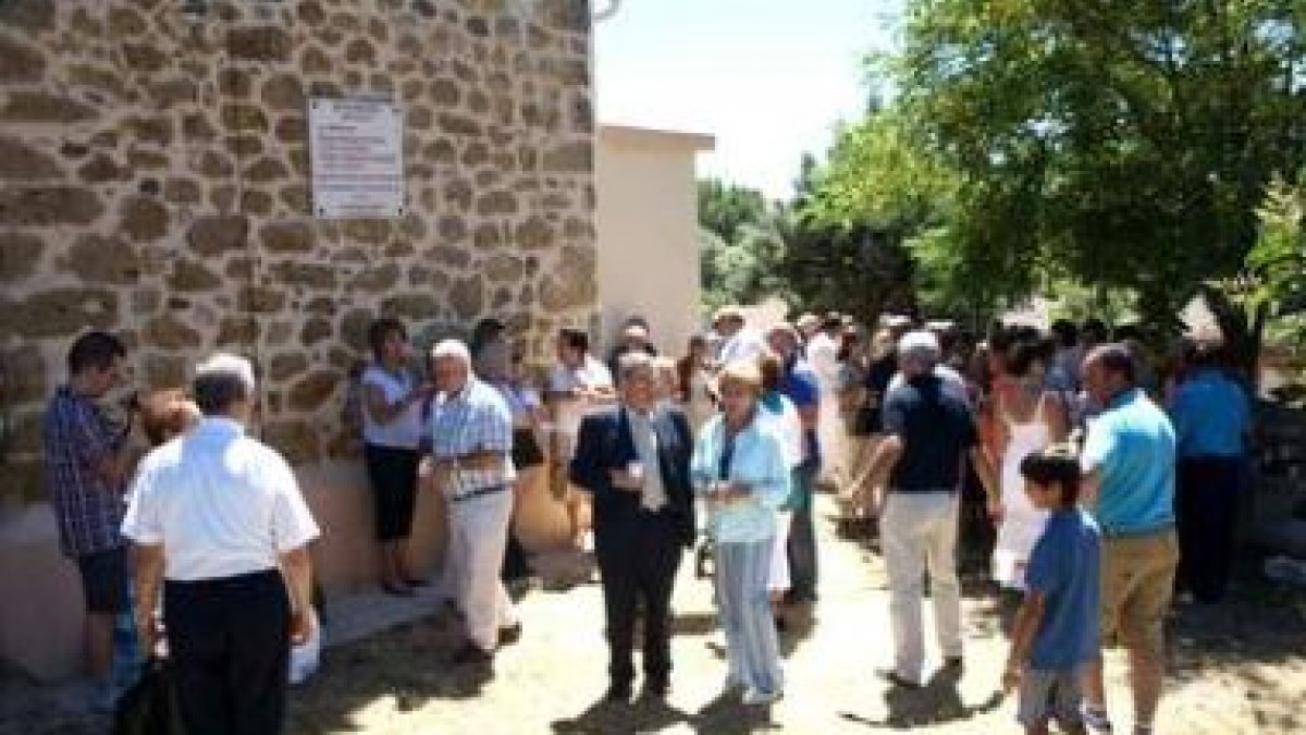 Los vecinos junto a la placa colocada en la iglesia.