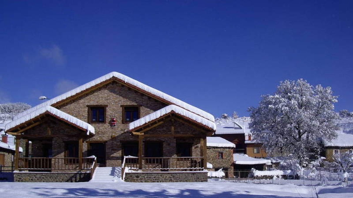 Casa Lara bajo una intensa nevada y comedor de este alojamiento rural de San Martín de Valdetuéjar.