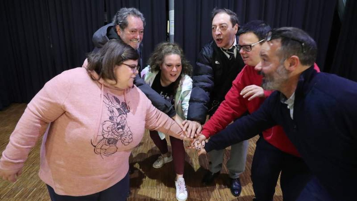 El equipo de ‘Temporada de champiñones’ realiza el gesto de los campeones deportivos al finalizar el ensayo en la casa de cultura de Trobajo del Cerecedo. RAMIRO