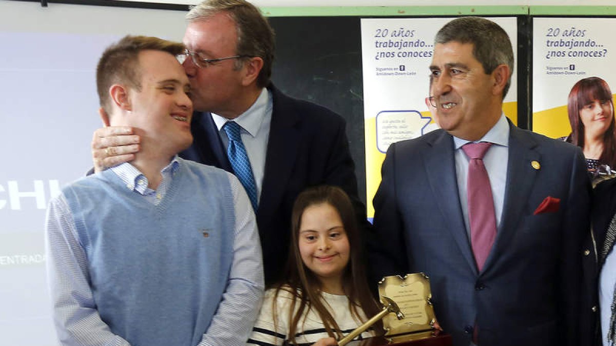 Antonio SIlván, besa a Aitor en presencia de Eva, con el martillo solidario, y el presidente de Amidown José Manuel Sánchez . MARCIANO