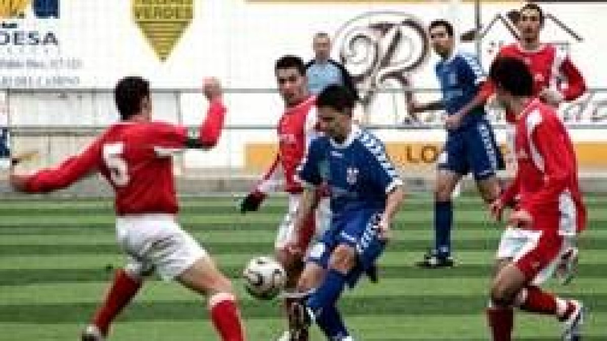 El jugador trepalense Alfonso, rodeado de contrarios, trata de controlar el esférico
