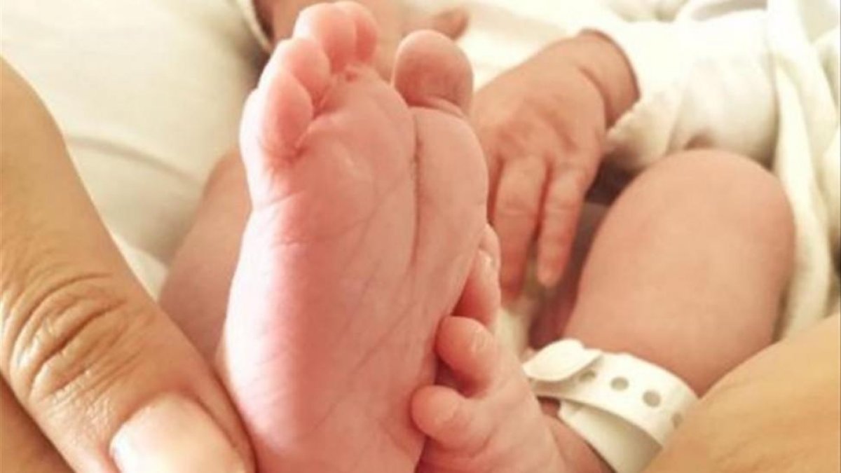 Tierna instantánea de los pies de Elías y la mano de su madre.