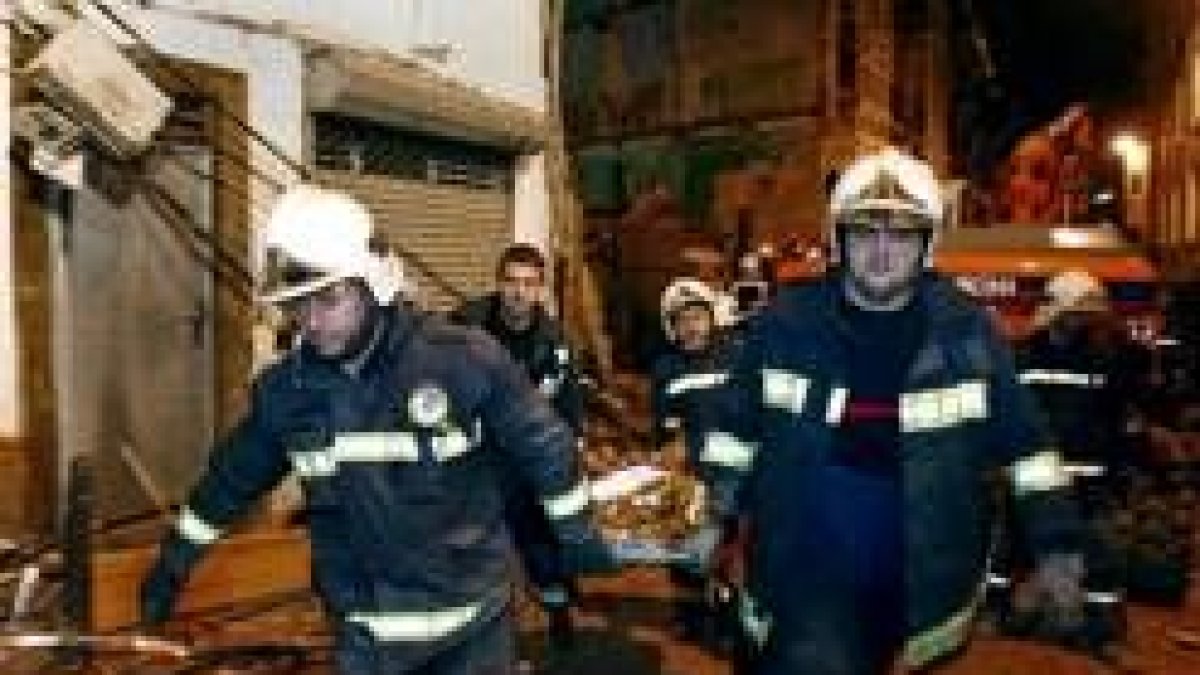 Efectivos del cuerpo de bomberos en el momento de trasladar el segundo cadáver encontrado