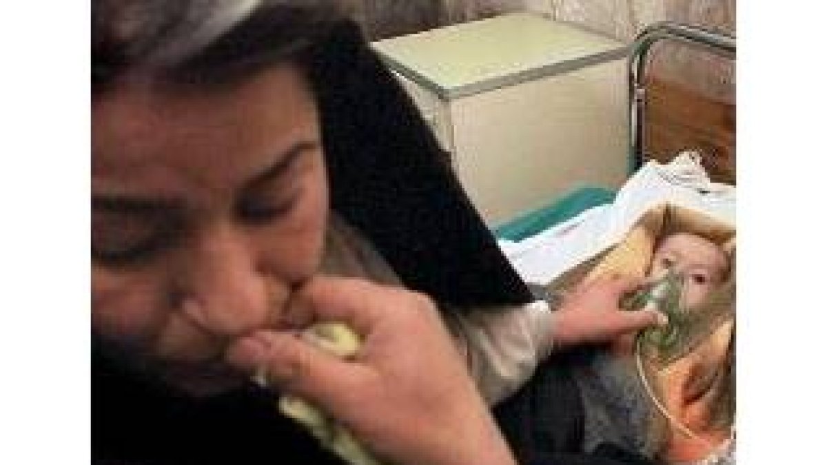 Una mujer iraquí ayuda a su hijo, que tiene leucemia, en un hospital de Bagdad