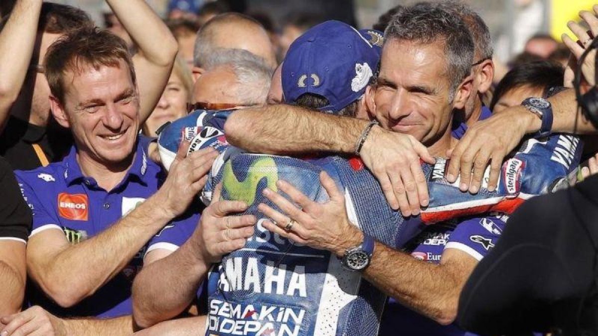 Jorge Lorenzo se despide, bajo el podio de Cheste, de su telemétrico Davide Marelli, a la derecha, el hombre de los datos.