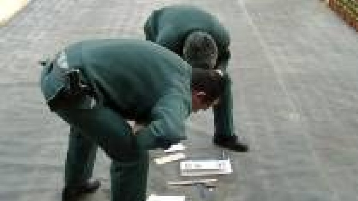 Dos miembros de la Guardia Civil inspeccionan el trozo de meteorito