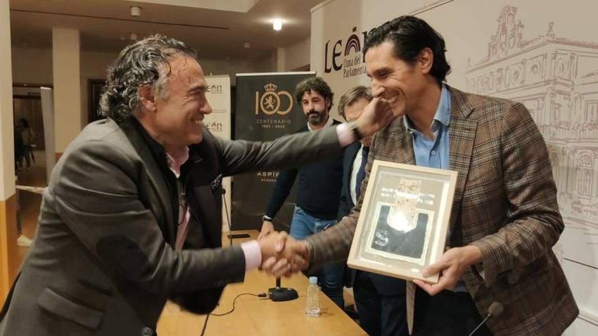 Sergio Fernández recibe un obsequio de Llamazares en un acto del Centenario del club leonés. DL