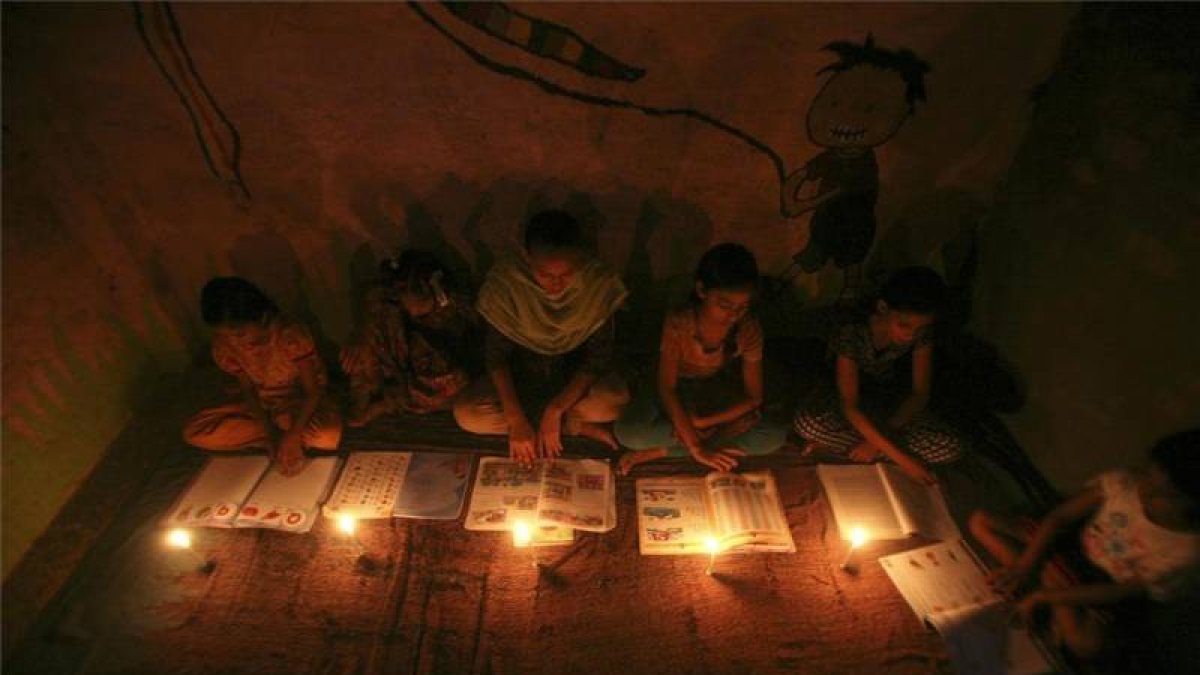 Varias niñas estudiando a la luz de unas velas en una escuela religiosa de Nueva Delhi